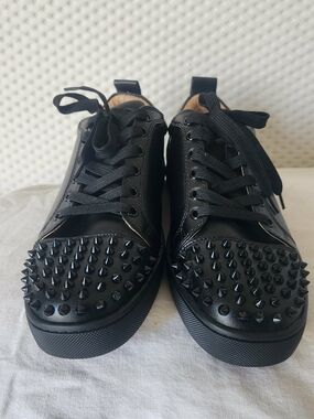 Christian Louboutin Louis Junior Spikes sneakers in black calf leather. 